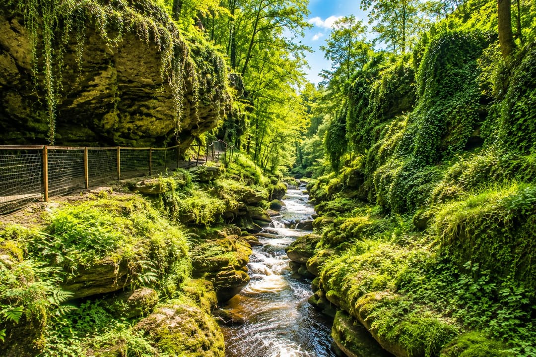 The limestone walls of How Stean Gorge with metal walkways above the rushing beck