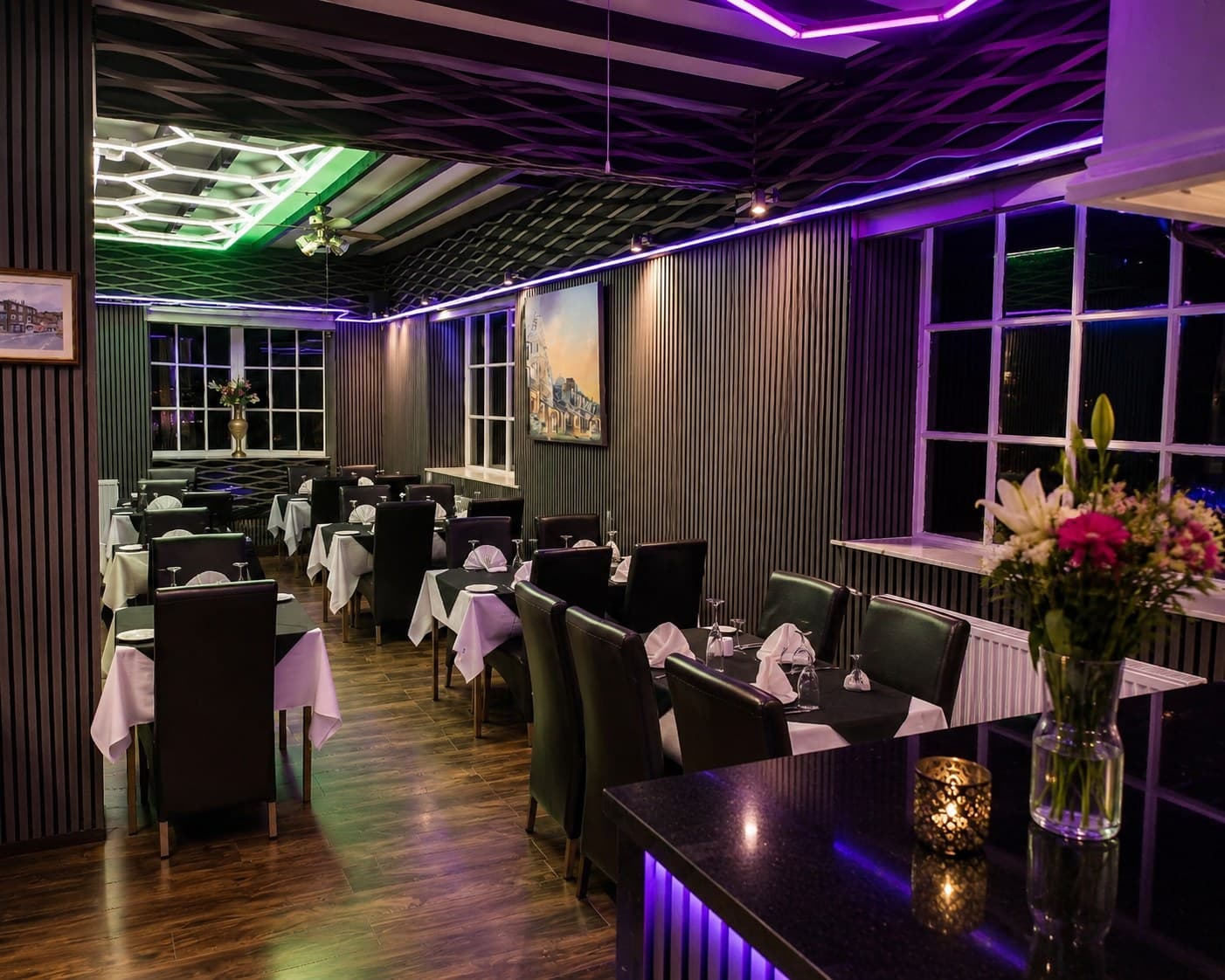 The stylish dining room at Saffron Restaurant, with white-clothed tables, dark decor and mood lighting
