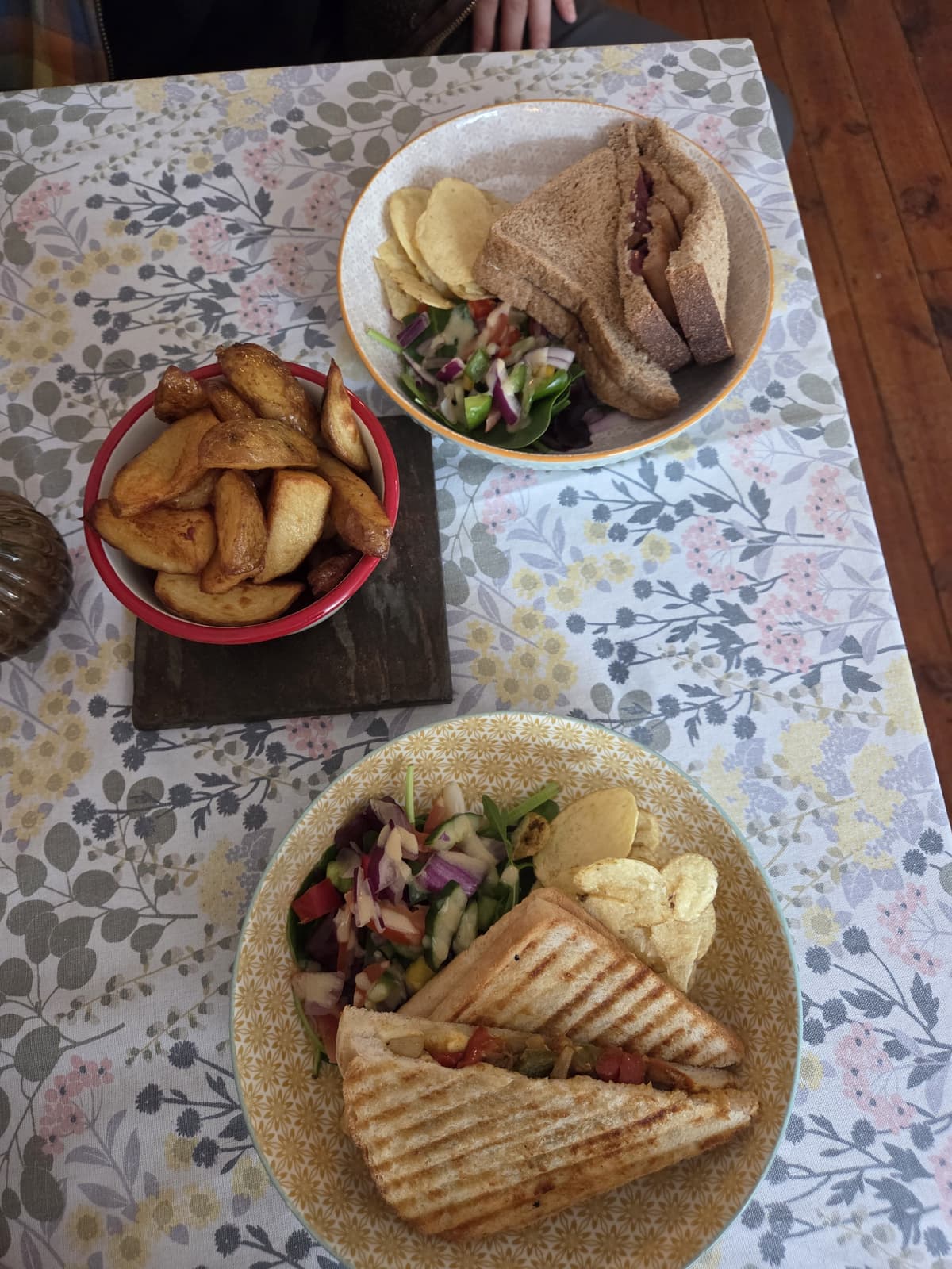 Homemade sandwiches, paninis and golden wedges on a floral tablecloth at Talbot House