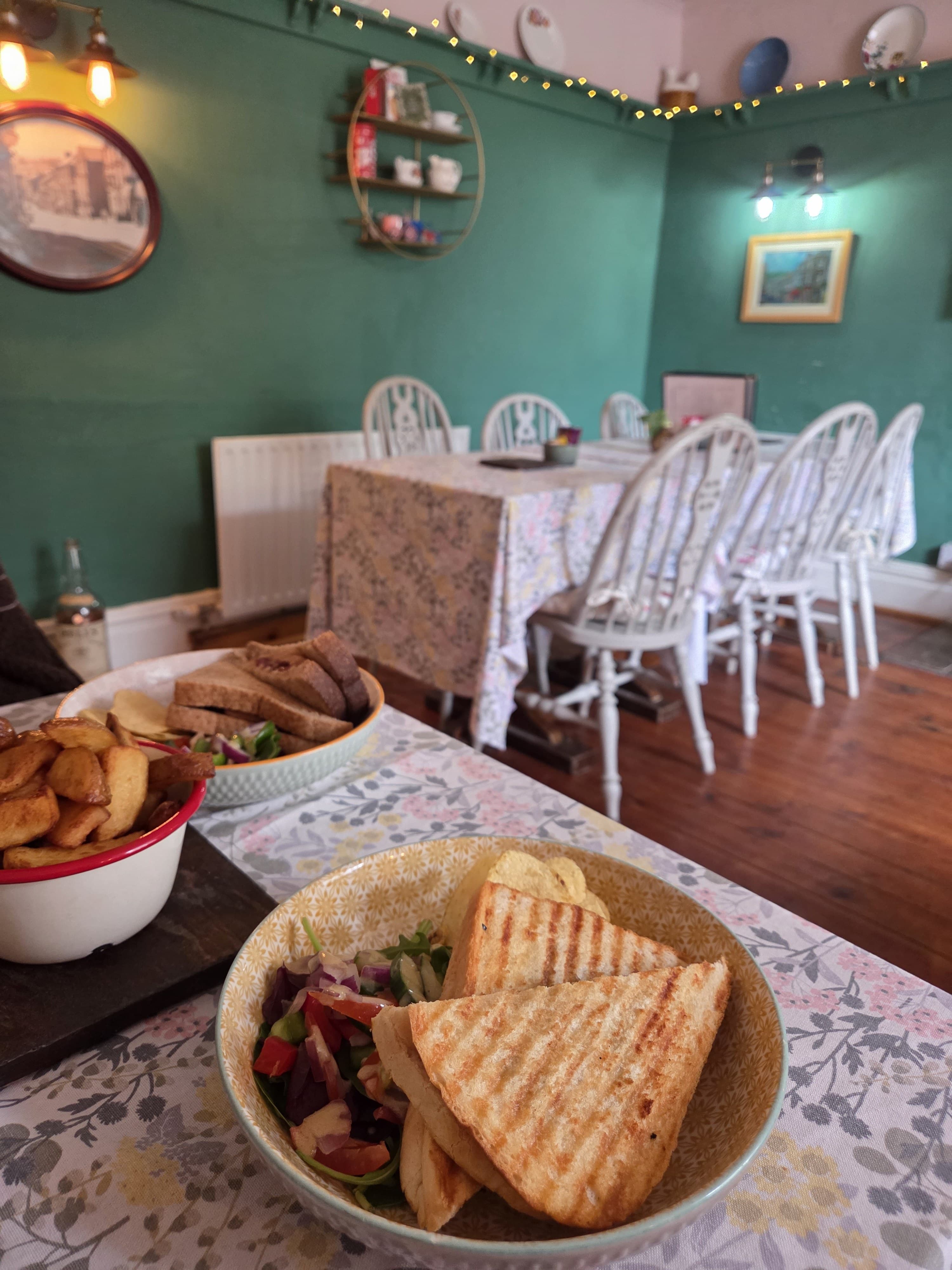 Grilled panini and homemade wedges served in the green-walled dining room with white vintage chairs